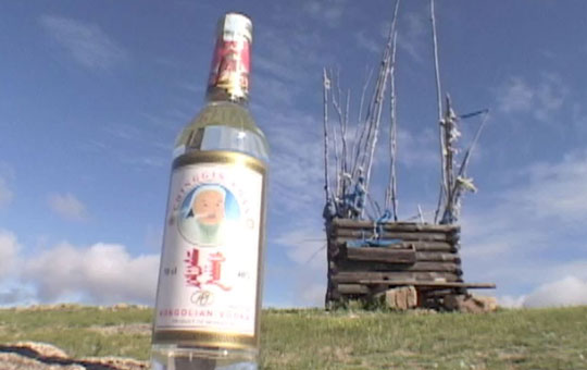 Bottle of vodka in the foreground, a hut in the background.